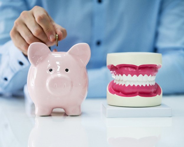 piggy bank beside artificial set of teeth  
