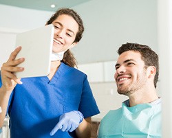 Dentist showing patient image on tablet