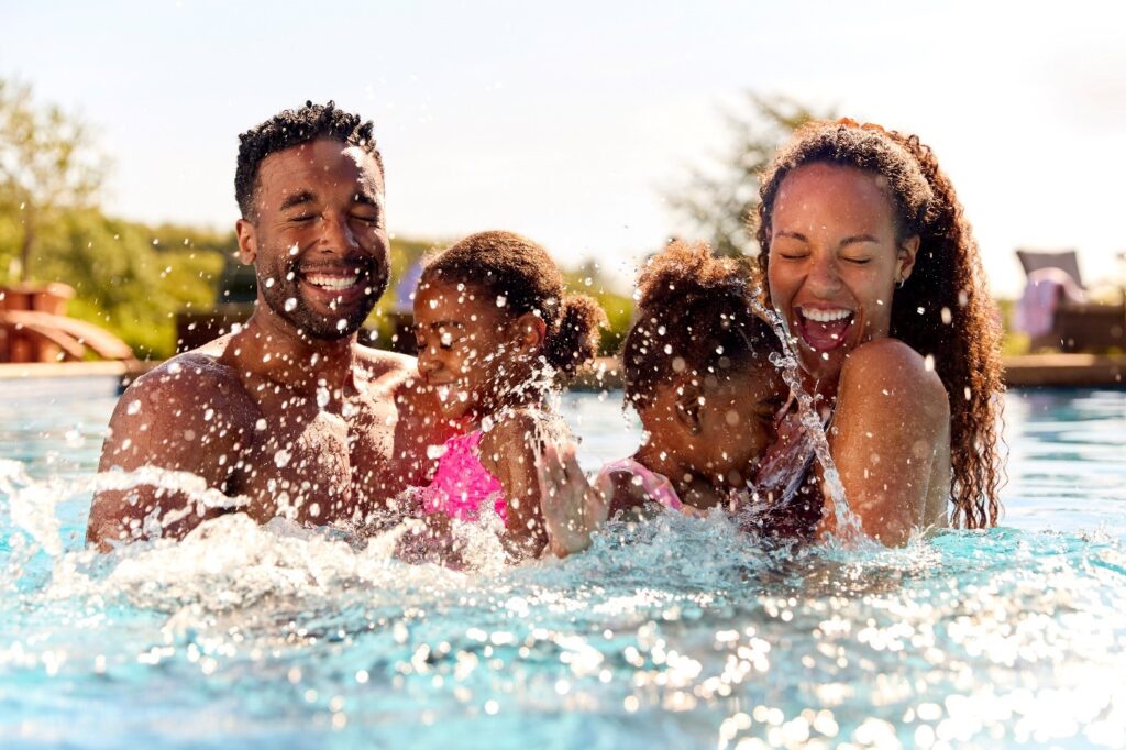 Smiling family splashing around in pool