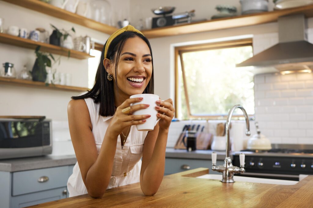 Woman smiling while drinking coffee at home