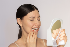 a person closely inspecting their swollen gums